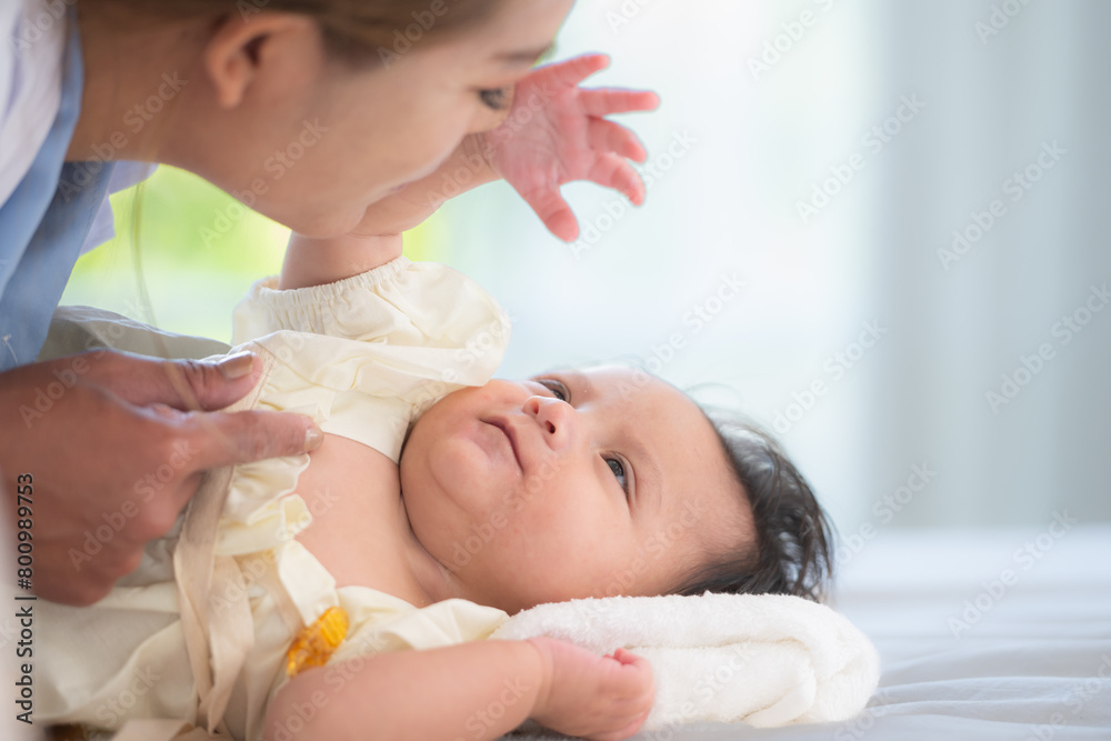 A mother plays with her little daughter in a bedroom full of warmth and family. A mother plays with her little daughter in a bedroom full of warmth and family.