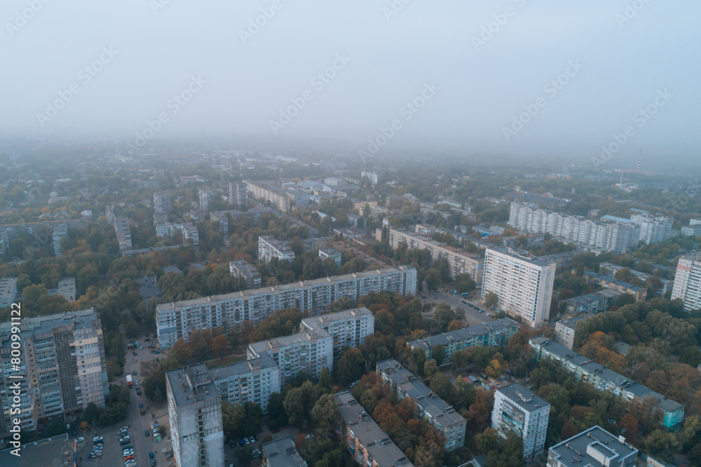 Fototapeta premium Aerial view of Dnipto city, Ukraine in fog. Cityscape. Panoramic view. Foggy metropolis. Ghost town. Atmospheric shot.