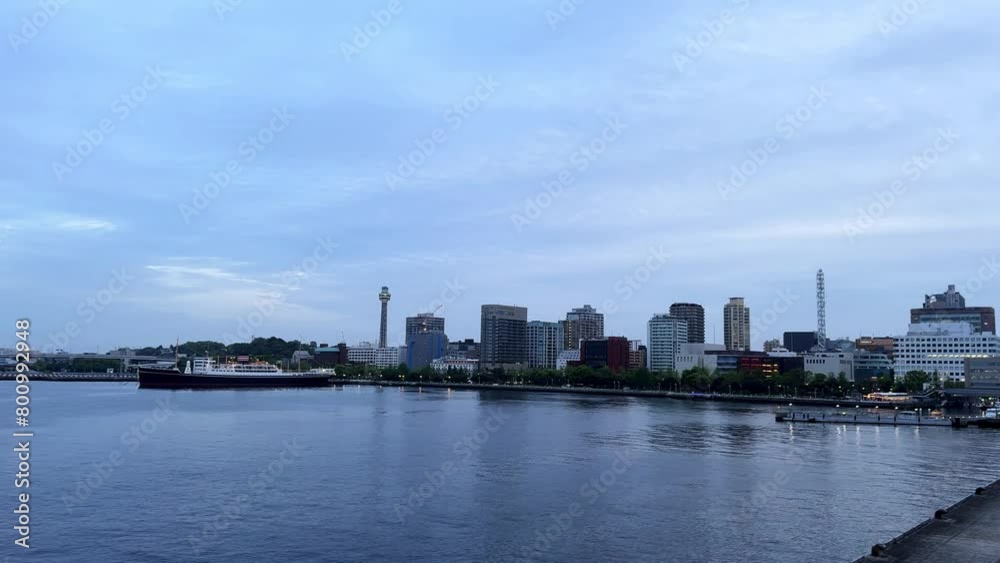 Dawn breaking over calm river with city skyline and clouds Dawn breaking over calm river with city skyline and clouds