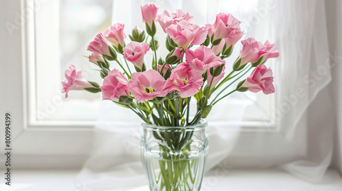 Glass vase with beautiful pink eustoma flowers on white