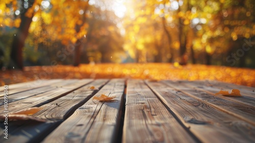 Autumn  yellow leafs on an empty wooden table  blurry background with sunlight