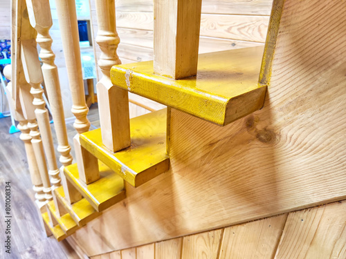 A pine wooden staircase with white balusters in a cozy home. Wooden Staircase in a Rustic Interior Setting