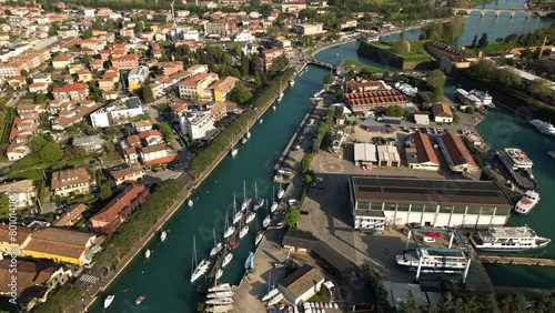 Aerial view of the city of Peschiera del Garda, Verona, Veneto. Top view of the canal with yachts. © Andrew