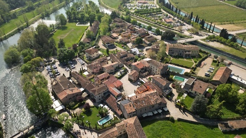 Beautiful little village aerial view of the mill village of Borghetto sul Mincio in the south of Lake Garda, in Veneto, Italy. Drone footage of the small medieval village 