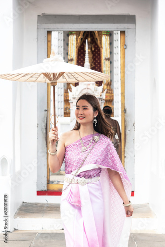 Tourist Asian woman wearing Thai national costume comes to visit an old church Thailand.