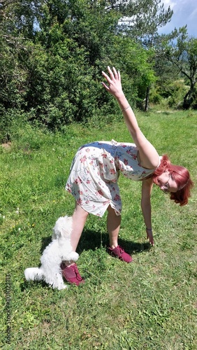 A woman playing with a Maltese dog