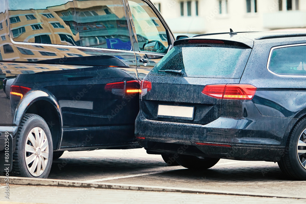 Car accident in parking lot, maneuvering unsafely in confined spaces. Parking accident due to limited visibility, distracted driving. Rear-up collision, driver is reversing and hit parked car