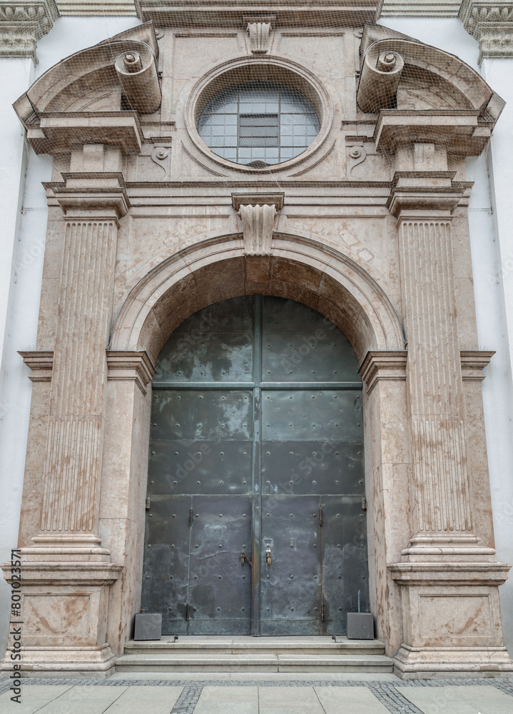 Entrance iron doorway and Decorated arch wall of St. Michael's Church (Michaelskirche Jesuit church) in Munich pedestrian zone. It is the largest Renaissance church north of the Alps. Space for text, 