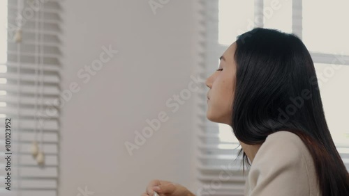 A beautiful Asian female entrepreneur is eating an instant noodles while working, she is consuming instant food in a hurry because of the deadline is coming, hungry but had to finish work in time