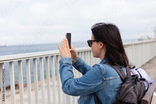 Side view of a woman taking a selfie on the promenade photo