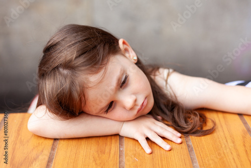 Canvastavla Portrait of a cute little girl sleeping on a wooden table.