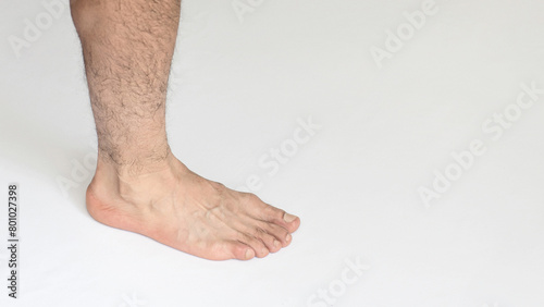 Adult man foot in closeup against a white background with space for text, showing inner ankle view.