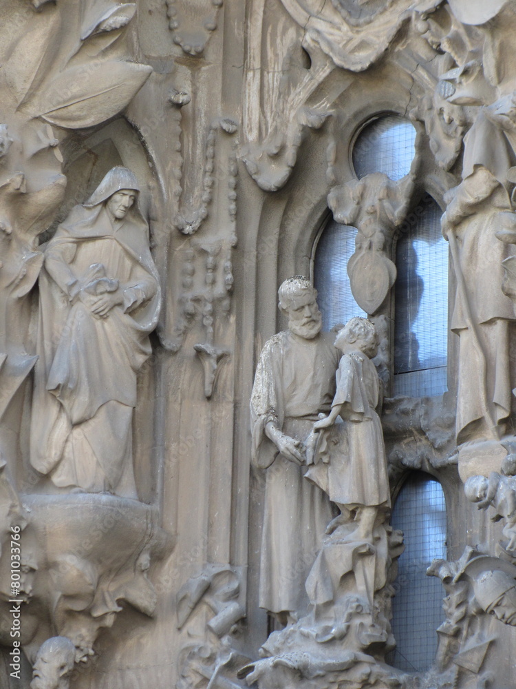 Statues with a biblical, religious scene, made of gray granite, seen at the entrance of the Sagrada Familia church, in Barcelona, Spain