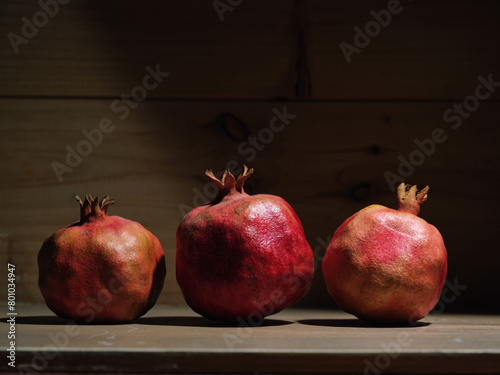 Red organic grown pomegranates in bright sunlight with copyspace. Natural fruit concept image.