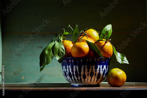 Fresh organic tangerines with leaves in bowl in bright sunlight with copy space. Still life with natural tropical fruit.
