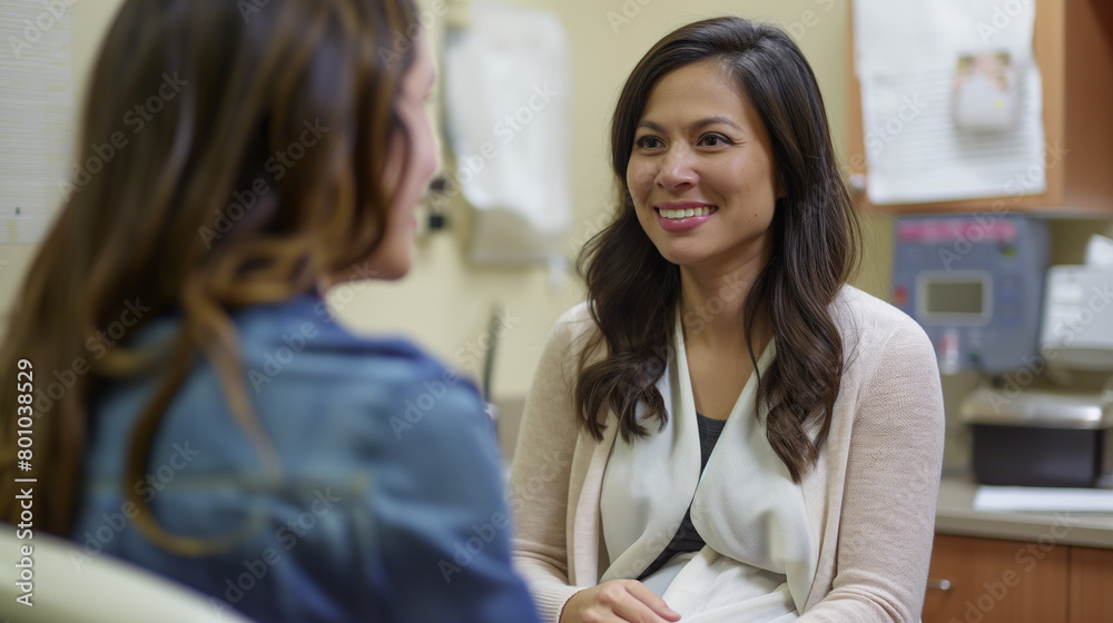 With a sense of calm, the woman shares her concerns and questions with her obstetrician, her smile growing as she receives informative and supportive responses during her prenatal With a sense of calm, the woman shares her concerns and questions with her obstetrician, her smile growing as she receives informative and supportive responses during her prenatal