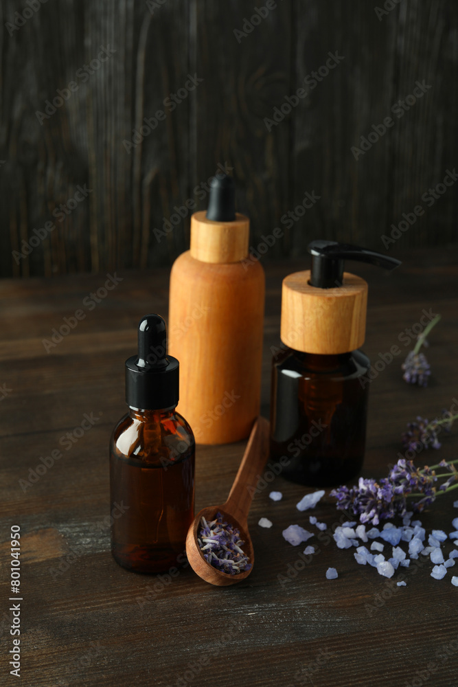 Lavender oil in bottles with lavender flowers on a dark background Lavender oil in bottles with lavender flowers on a dark background