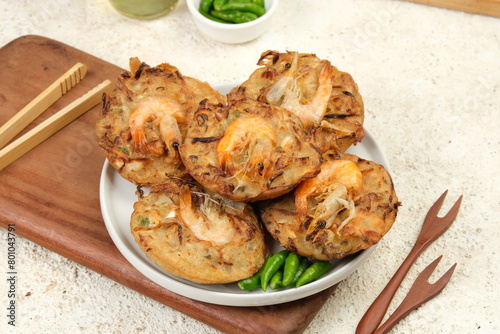 Bakwan Pontianak (bakwan udang) or vegetable fritters is an Indonesian traditional snack made from wheat flour mixed with vegetables and topping with dried shrimps. Served with raw chilli photo