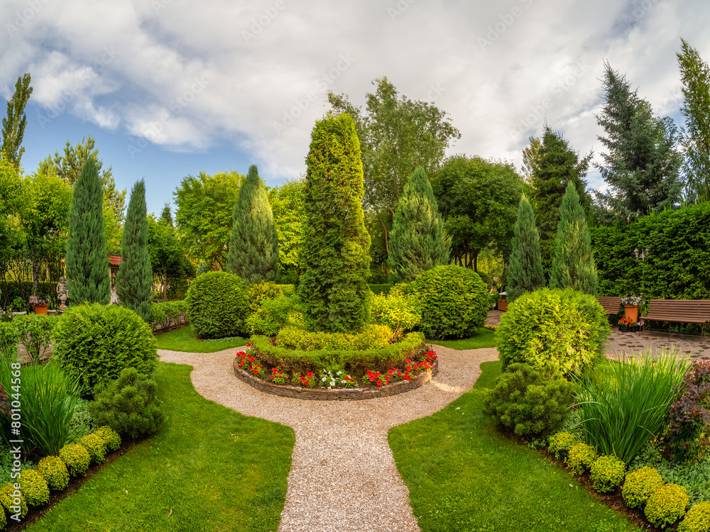 Summer garden courtyard. Bush lined path in park.