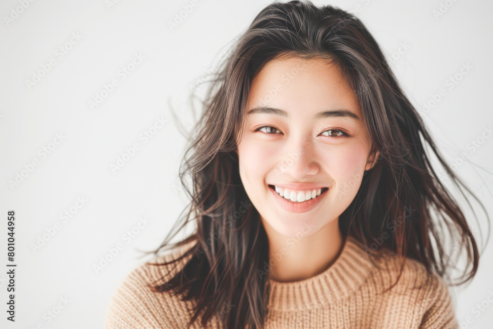 Beautiful studio portrait of young, stylish asian woman, long hair, smiling and looking at camera with confidence on white background Beautiful studio portrait of young, stylish asian woman, long hair, smiling and looking at camera with confidence on white background
