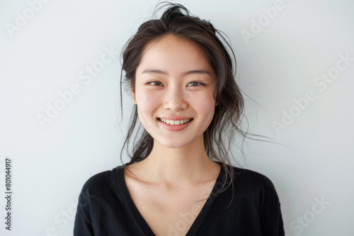Beautiful studio portrait of young, stylish asian woman, long hair, smiling and looking at camera with confidence on white background