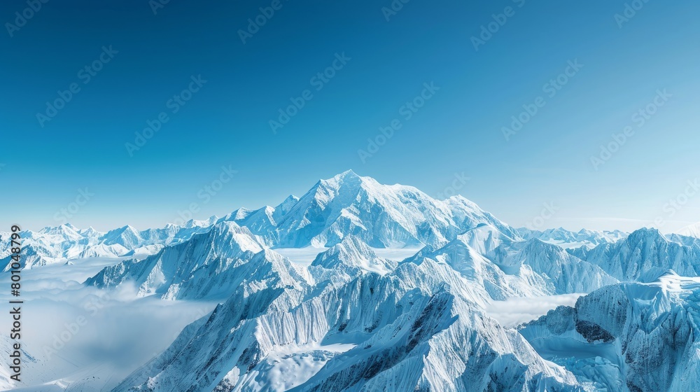 A panoramic view of a snow-covered mountain range in Alaska under a cloudy sky