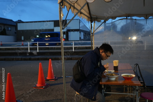 Man eating Ramen outside in Japan - 日本 奈良 屋台で彩華ラーメンを食べる男性 photo