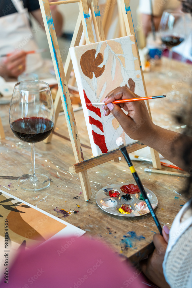 Fototapeta premium Painting and sip workshop. Woman enjoying art and wine.