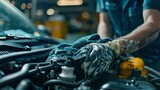 A mechanic wearing blue latex gloves is cleaning the engine of a car with a soapy cloth