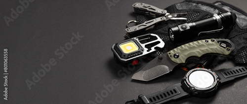 Everyday carry EDC items for men in black color - flashlight, watch and knife. Survival set. Minimal concept photo