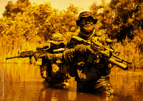 Soldiers move in the heart of a marsh, crossing swampy waters, tropical jungle heat, extreme conditions of concealed tactical combat operations of special task forces photo
