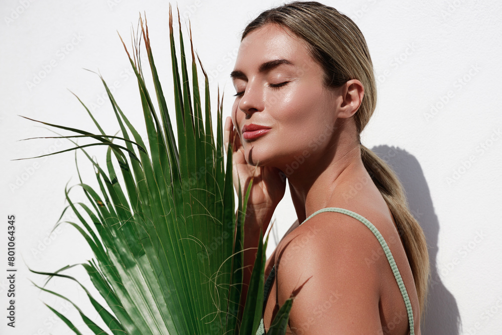 Portrait of Beautiful Young Woman Posing with Palm Leaf on White Background Portrait of Beautiful Young Woman Posing with Palm Leaf on White Background