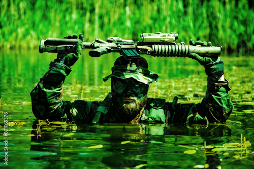 A soldier moves in the heart of a marsh, submerged in swampy waters with only arms and rifle visible, extreme conditions of concealed tactical combat operations of special task forces