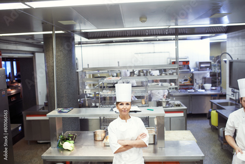 Chef, woman and confident in industrial kitchen, restaurant and gourmet meal prep and serving. Crossed arms, catering service and culinary skills, nutrition and working in hospitality industry photo