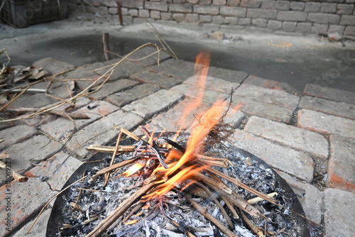 Smoldering wood fire. The fire is being kindled by blowing. Wooden fire.  Rural area in India.