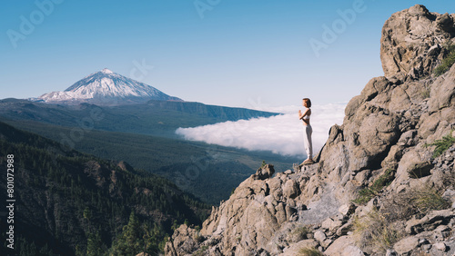 Woman doing yoga and meditating on background of natural landscape photo