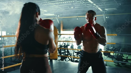 A male and female boxer train together, exchanging punches and practicing defensive techniques in a well-lit gym environment, enhancing their boxing skills. Camera 8K RAW.  photo