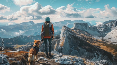 girl and dog standing on a mountain top looking at the view photo