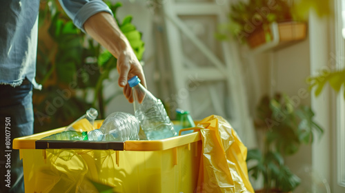 Man throwing empty plastic bottle in recycling bin