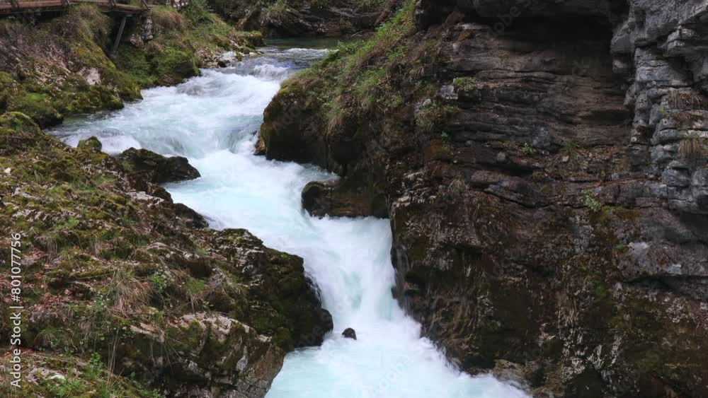 A mountain river flows into a gorge with powerful streams of water in Slovenia. A mountain river flows into a gorge with powerful streams of water in Slovenia.