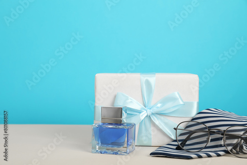 Happy Father s Day. Tie  glasses  perfume and gift box on beige table  closeup. Space for text