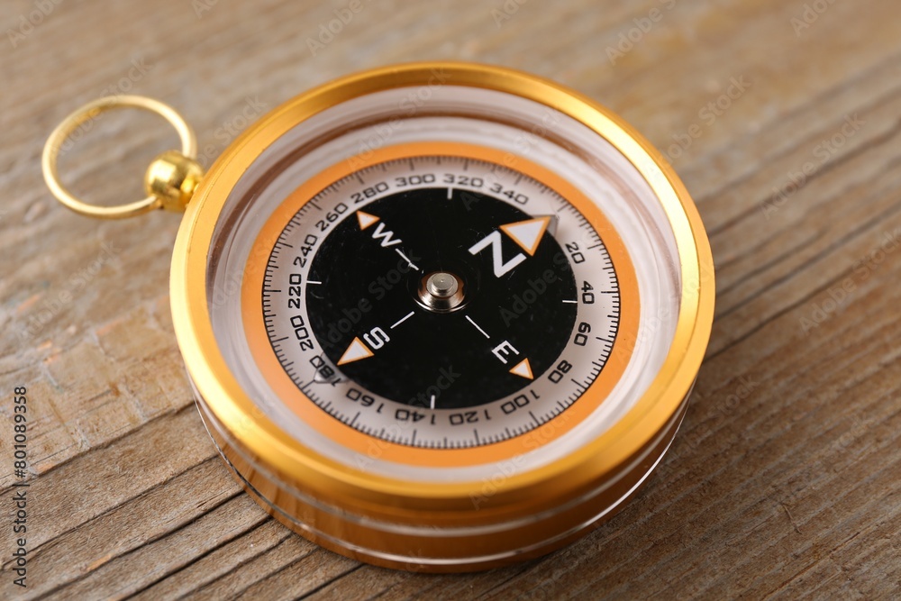 One compass on wooden table, closeup. Navigation equipment One compass on wooden table, closeup. Navigation equipment