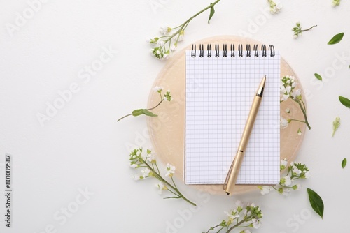 Guest list. Notebook, pen and beautiful spring tree blossoms on white background, flat lay. Space for text