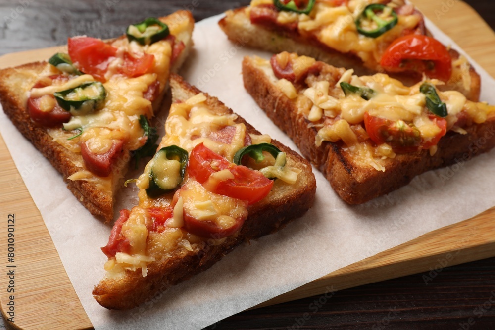 Tasty pizza toasts served on wooden table, closeup