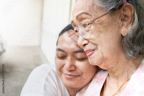 An Asian old mother smiling and happy being hug by her daughter