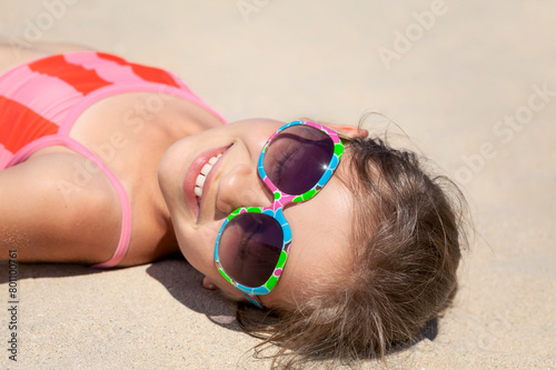 Children Holiday in Sandy Beach. Happy Child Teenager in Glasses Lies on Sand Beach Sunbathing. Smiling Teen Enjoying Life on Sandy Coast.