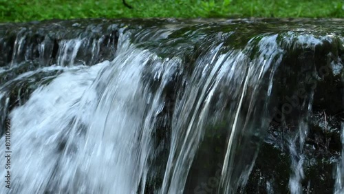 Streams of water flowing from the Jeleń waterfall in a nature reserve