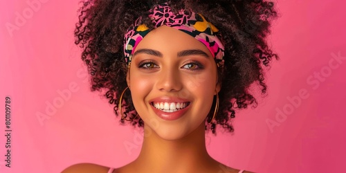 Bright and buoyant, a woman's beaming smile and stylish headband pop against a playful pink background, embodying lively beauty and trendy fashion.