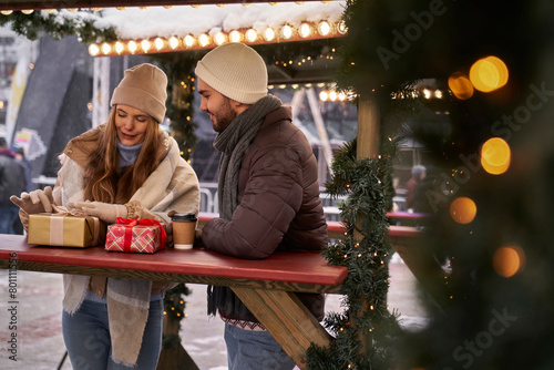 Caucasian couple on Christmas market with Christmas presents © gpointstudio