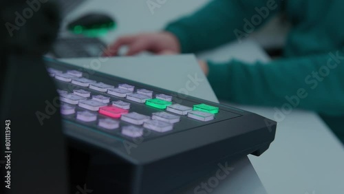 An engineer switching channels on black control panel. The control panel is on a white table